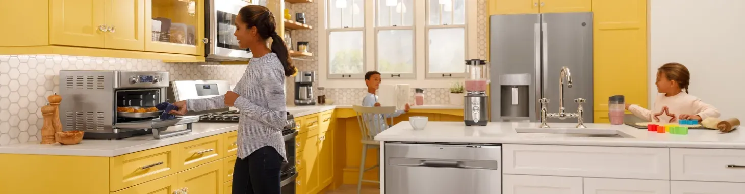 mother and children in a kitchen with yellow themed cabinets